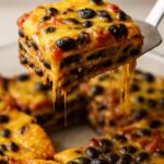 Southwestern Black Bean Casserole with layers of black beans, cheese, and savory sauce in a glass baking dish.