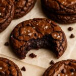 Close-up of a fudgy chewy brookie cookie with a gooey center and flaky top, sprinkled with sea salt.
