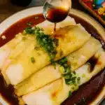 Shrimp Rice Paper Rolls Dim Sum drizzled with soy sauce and garnished with chopped green onions.