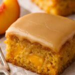 Moist slice of brown sugar peach cake topped with rich brown sugar glaze and fresh peach chunks.