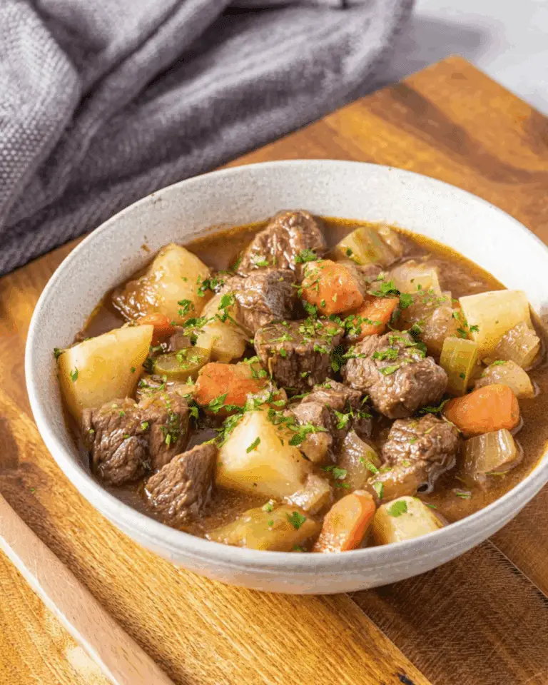 Bowl of beef stew with chunks of beef, potatoes, carrots, and celery in a rich broth.