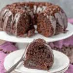 Chocolate Zucchini Bundt Cake with a slice served on a plate, showcasing its moist interior and chocolate glaze.