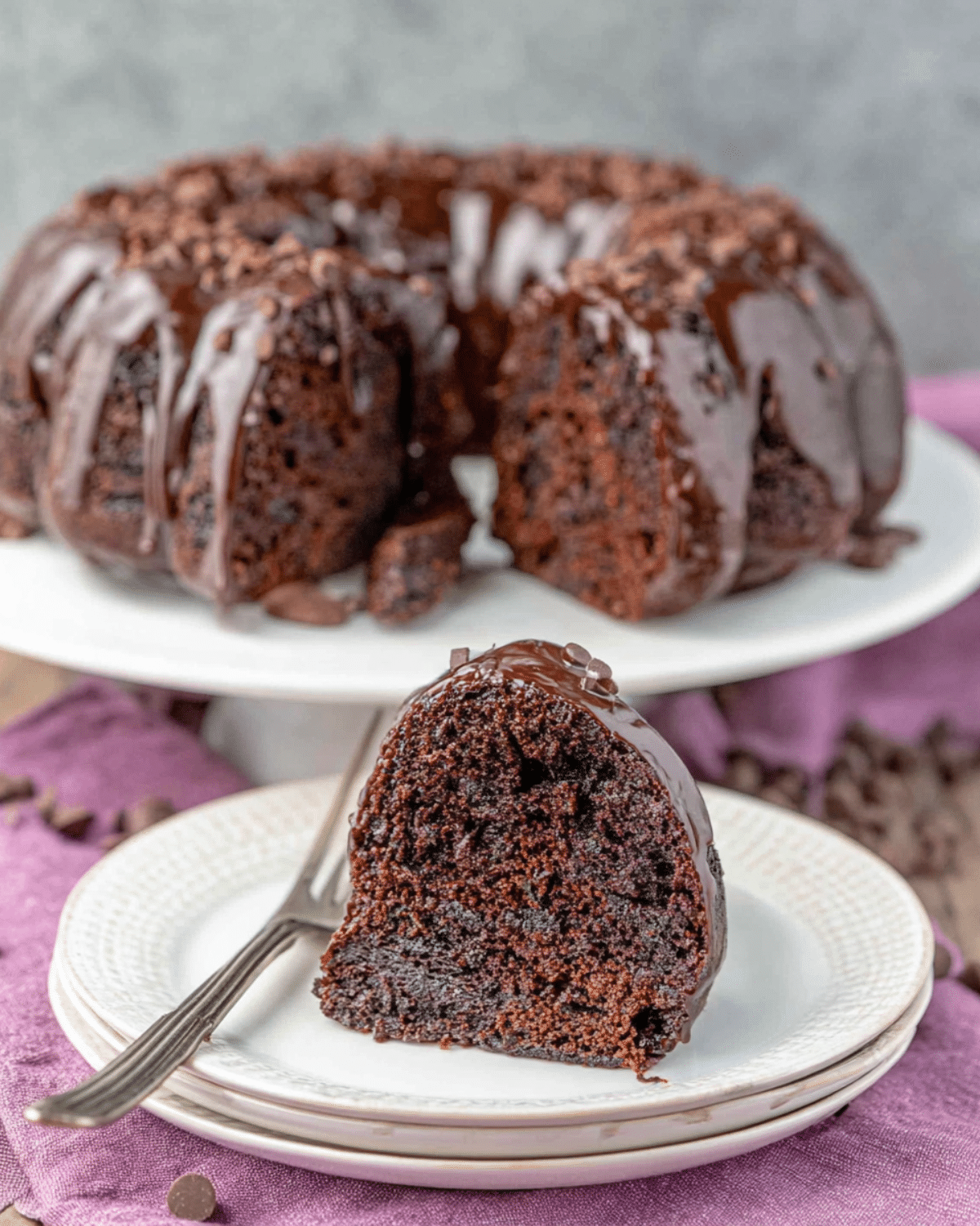 Chocolate Zucchini Bundt Cake with a slice served on a plate, showcasing its moist interior and chocolate glaze.