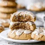 A stack of Coffee Cake Cookies filled with a gooey cinnamon center, topped with white icing drizzle and crumbly streusel.