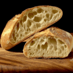 Crusty batard bread sliced open to reveal a soft, airy interior with a golden, crisp crust.