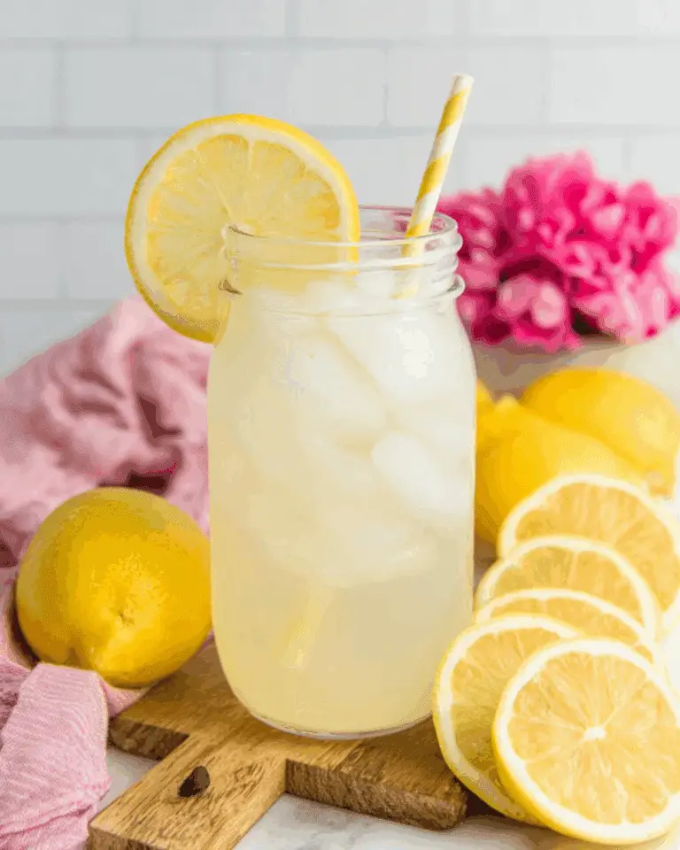 Freshly Squeezed Lemonade in a mason jar with ice, a lemon slice garnish, and a yellow-striped straw.