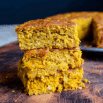 Stacked slices of healthy pumpkin oatmeal breakfast cake on a wooden board, showing moist and dense texture.