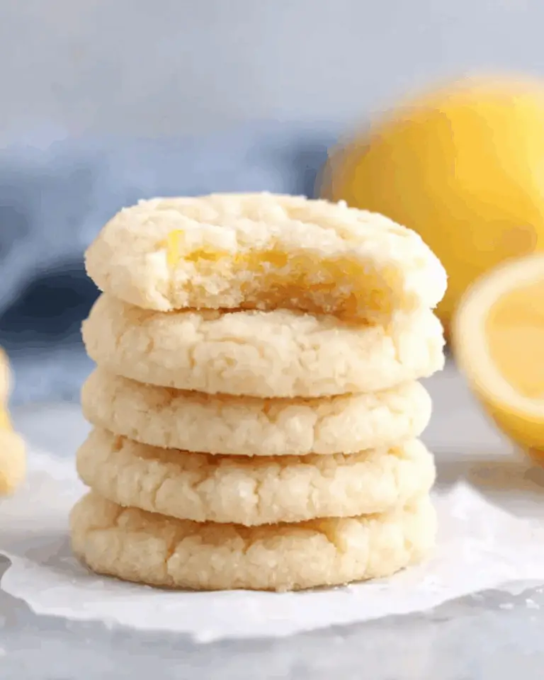 Stack of soft Lemon Sugar Cookies with a bite taken out of the top cookie