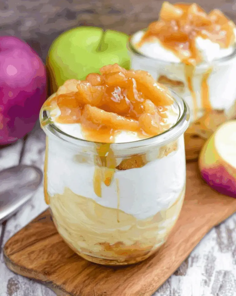 No Bake Caramel Apple Pie Cheesecake Parfaits in glass jars, layered with apple filling, cheesecake mousse, and caramel sauce.