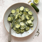 Bowl of ranch cucumber salad with sliced cucumbers, onions, and a creamy ranch dressing.