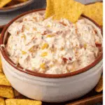 Bowl of creamy Rotel ranch dip filled with diced tomatoes, peppers, and herbs, served with tortilla chips.