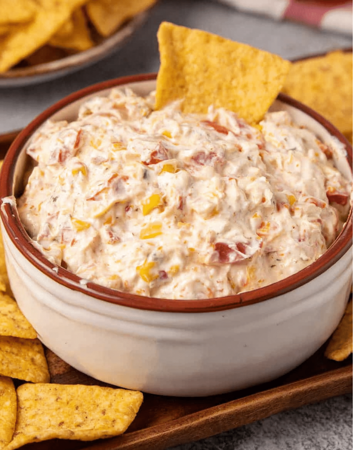 Bowl of creamy Rotel ranch dip filled with diced tomatoes, peppers, and herbs, served with tortilla chips.