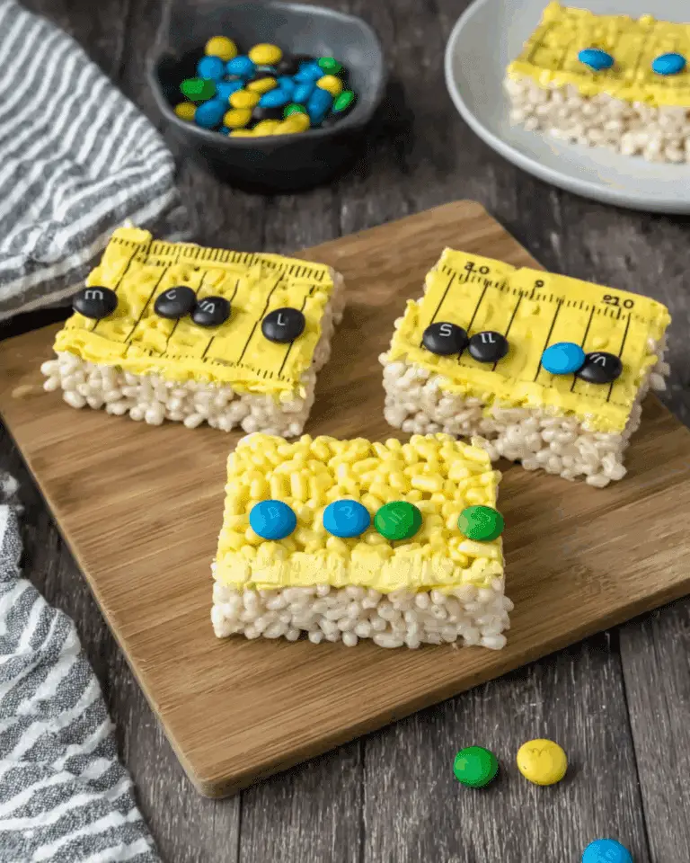 Ruler Rice Krispies treats topped with yellow frosting, black ruler lines, and colorful candy decorations.