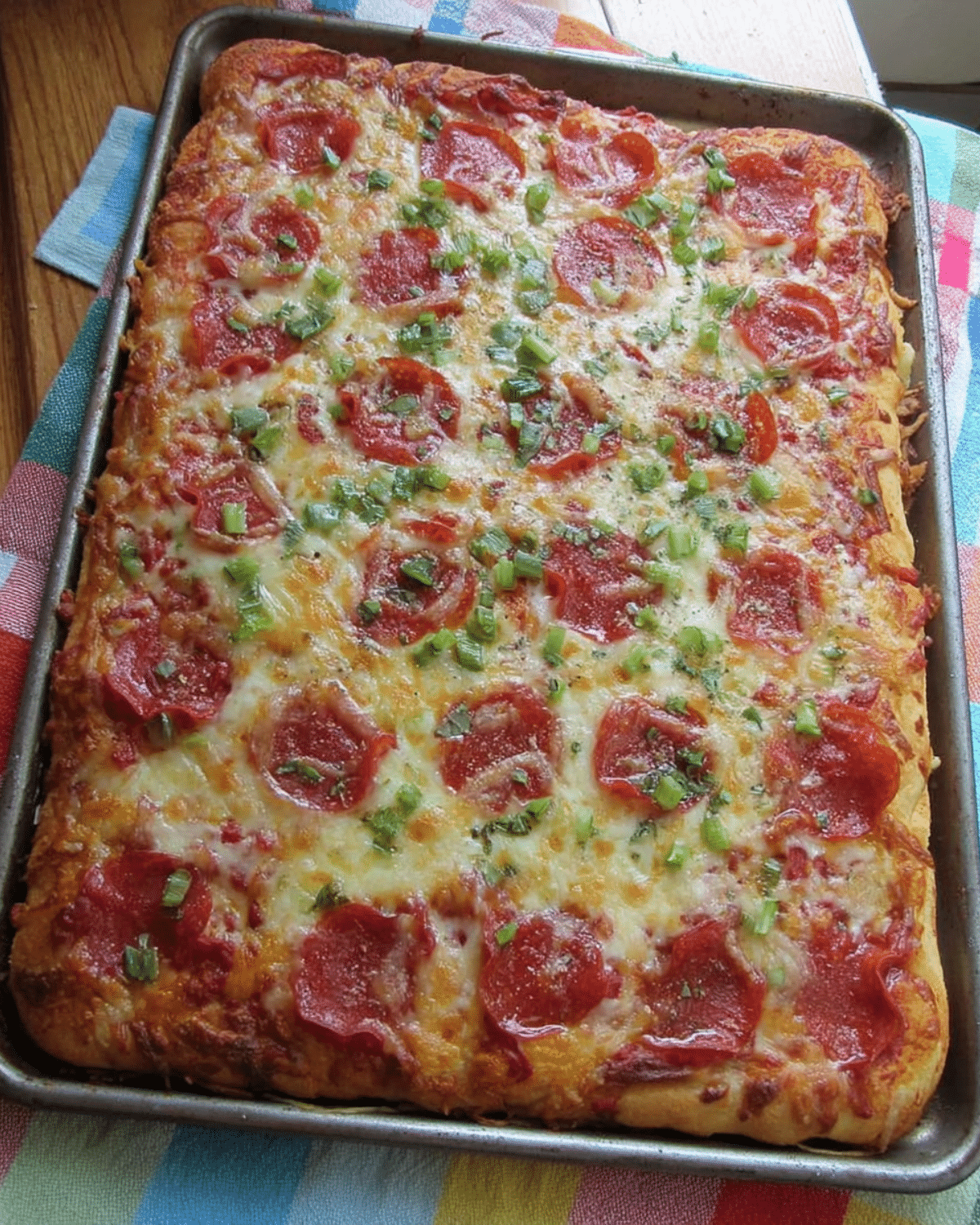 A large rectangular tray of School Cafeteria Pizza topped with pepperoni, melted cheese, and chopped green onions.