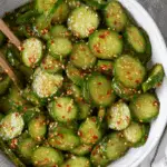 A bowl of Tik Tok Korean Cucumber Salad with sliced cucumbers coated in a spicy, sesame-filled dressing.