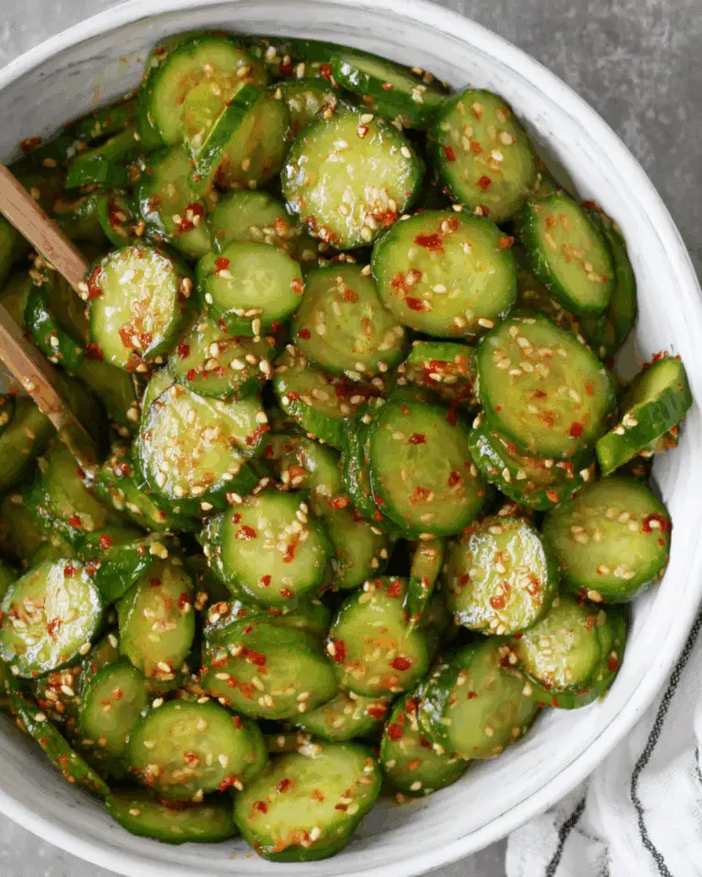 A bowl of Tik Tok Korean Cucumber Salad with sliced cucumbers coated in a spicy, sesame-filled dressing.