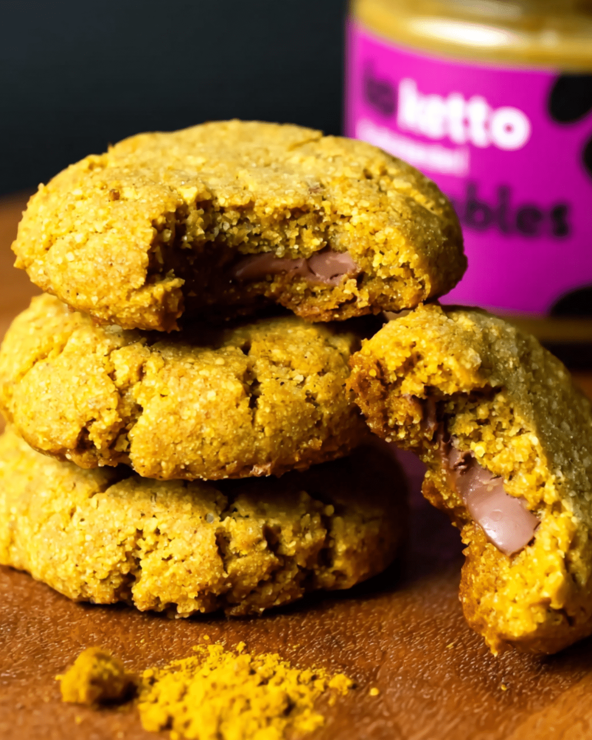 Stack of 3 ingredient keto pumpkin cookies with one broken open to reveal a soft, chocolatey center.