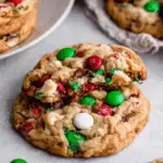 Christmas Kitchen Sink Cookies packed with red, green, and white candies, chocolate chips, and festive mix-ins on a light surface.