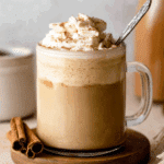Glass mug filled with coffee topped with whipped cream and cinnamon, featuring homemade pumpkin spice coffee creamer.