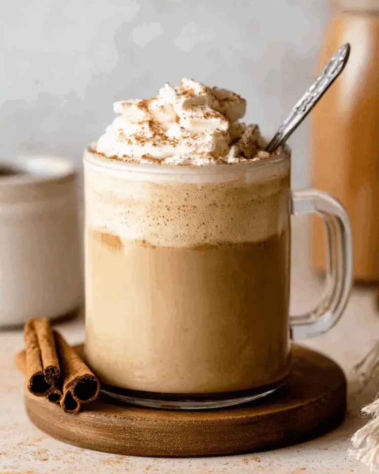 Glass mug filled with coffee topped with whipped cream and cinnamon, featuring homemade pumpkin spice coffee creamer.