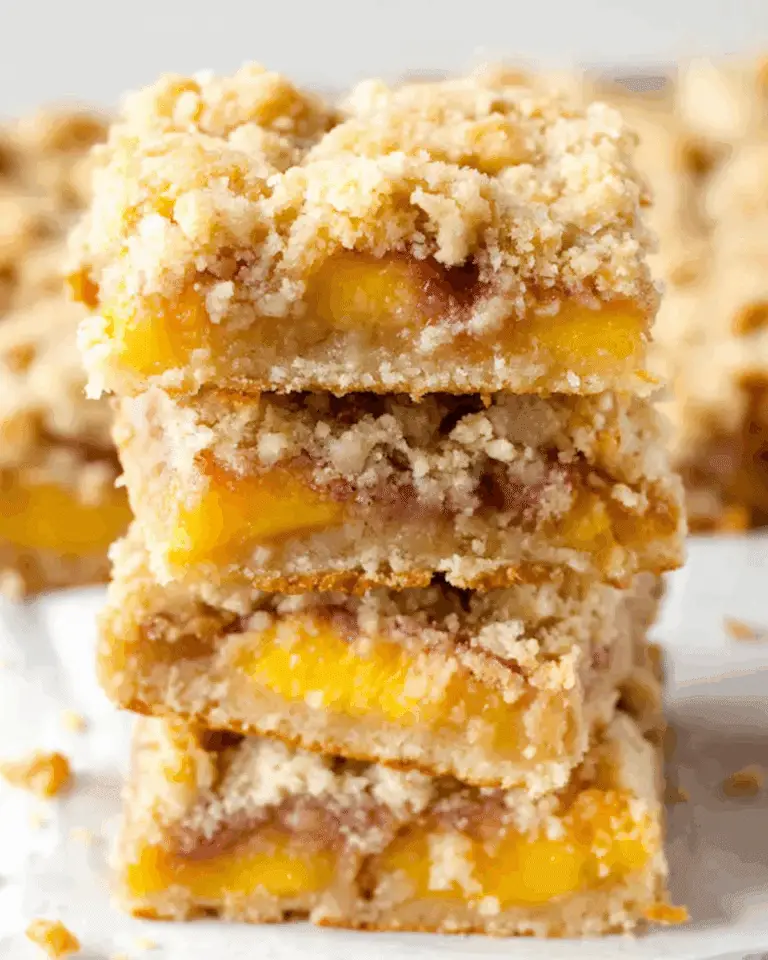 Stack of nectarine crumble bars with a golden buttery topping and fruity filling.