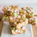 Stack of no bake butterscotch marshmallow bars with colorful mini marshmallows on a marble board.