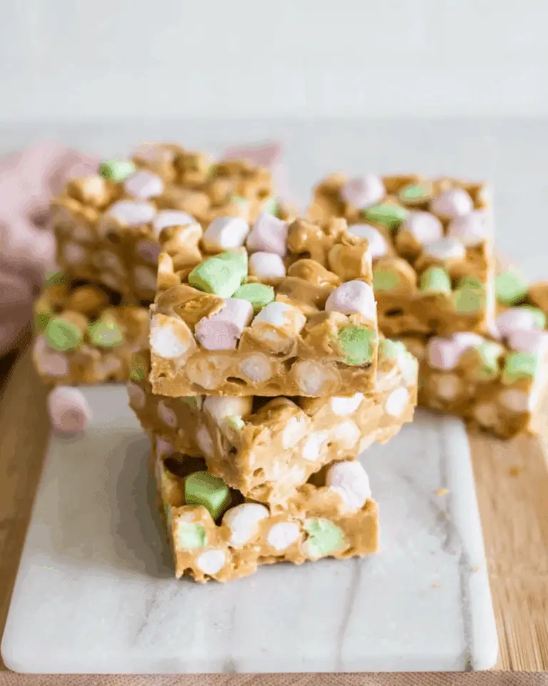 Stack of no bake butterscotch marshmallow bars with colorful mini marshmallows on a marble board.