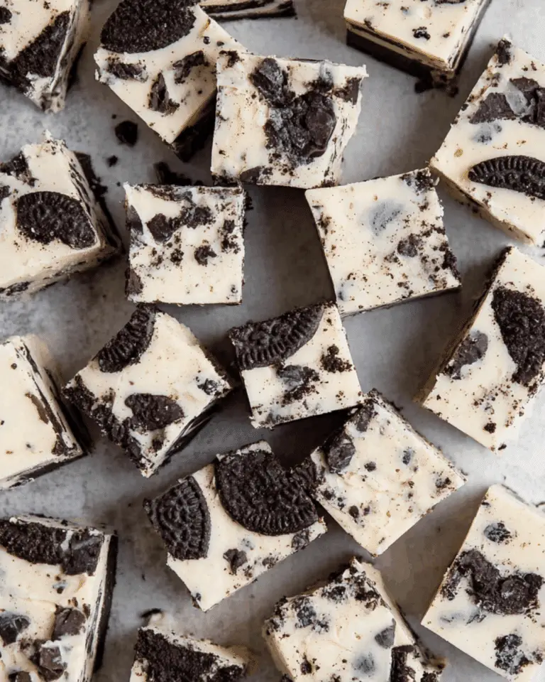 Close-up view of multiple pieces of Oreo Fudge with creamy white chocolate and chunks of Oreo cookies.