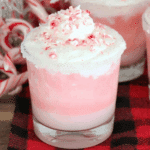 Peppermint Christmas Float in a clear glass with pink soda, whipped cream, and crushed peppermint candy on top.