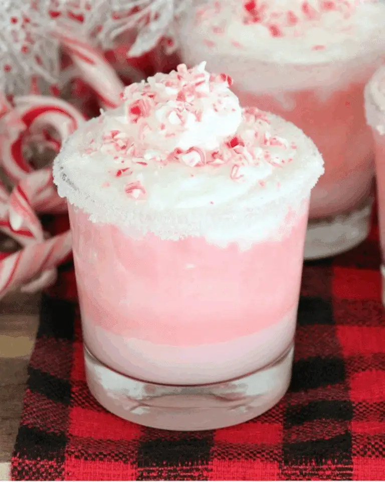 Peppermint Christmas Float in a clear glass with pink soda, whipped cream, and crushed peppermint candy on top.