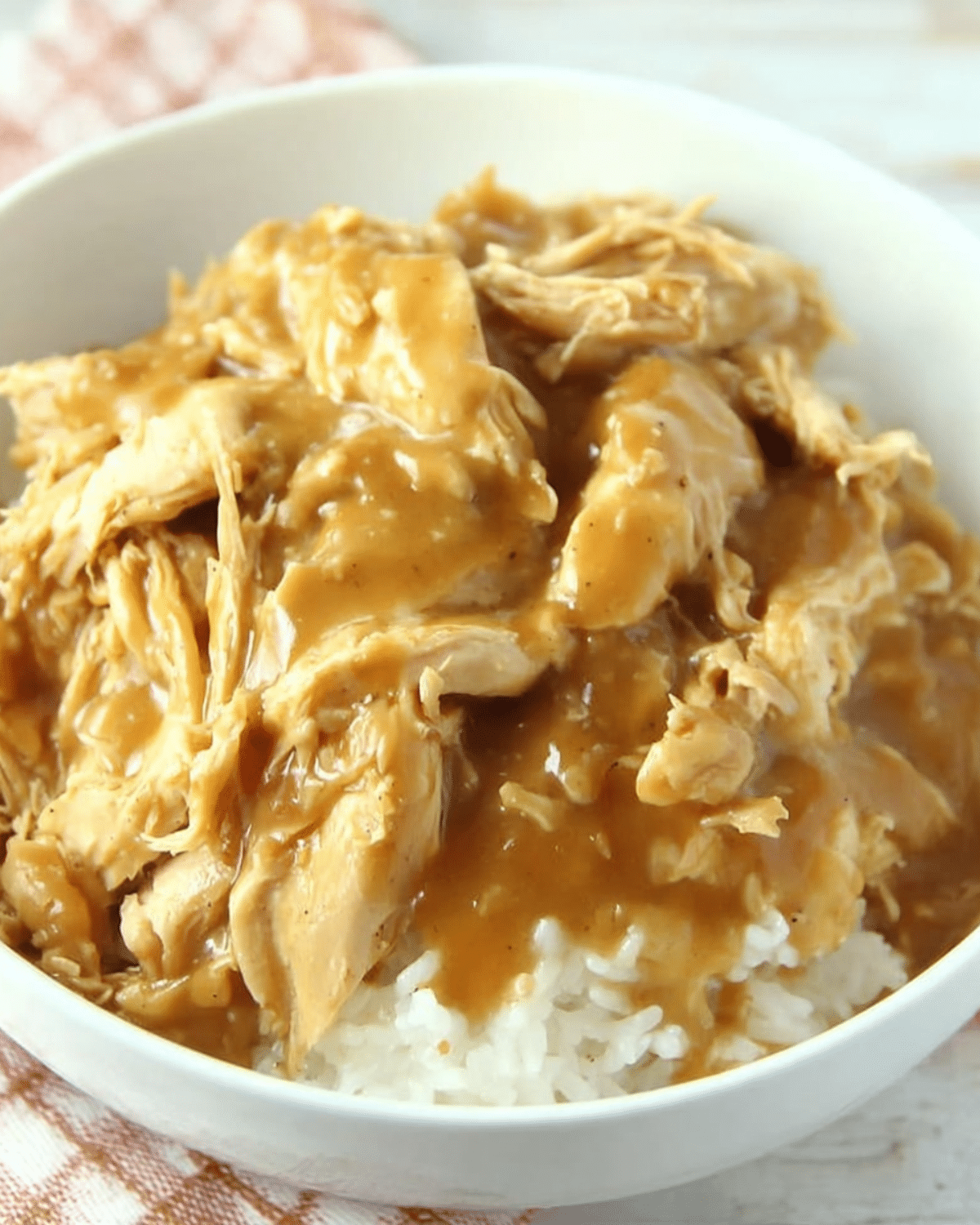 Bowl of slow cooker chicken and gravy served over white rice