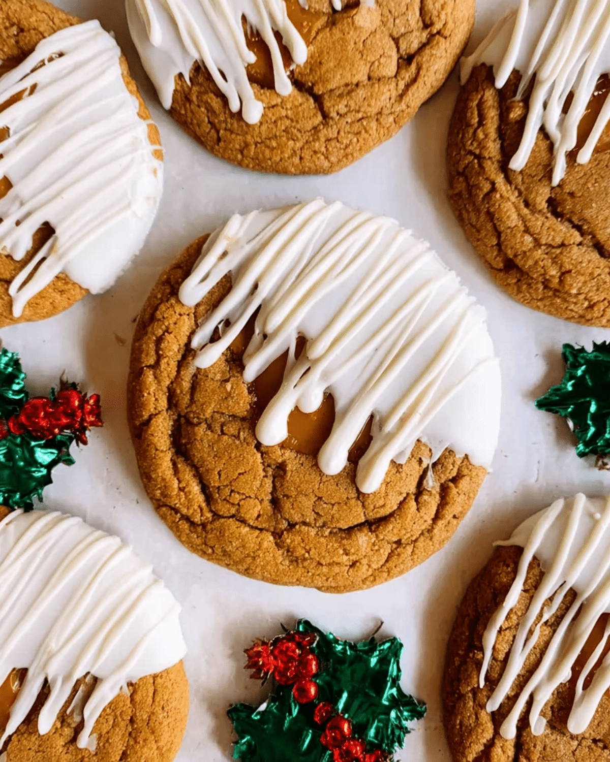White Chocolate Dipped Chewy Maple Cookies topped with drizzled white chocolate and festive holly decorations nearby.