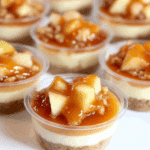 Individual CARAMEL APPLE DESSERT CUPS with layers of graham cracker crust, creamy filling, diced apples, and caramel sauce.