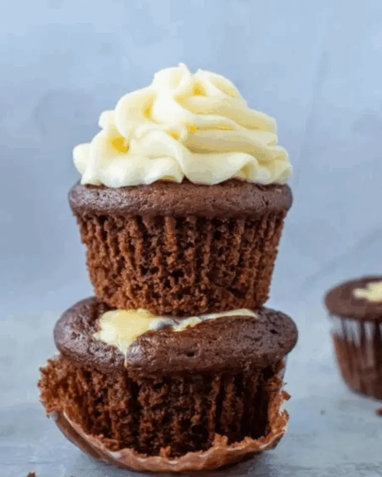Stacked cheesecake stuffed chocolate cupcakes with creamy frosting on top.