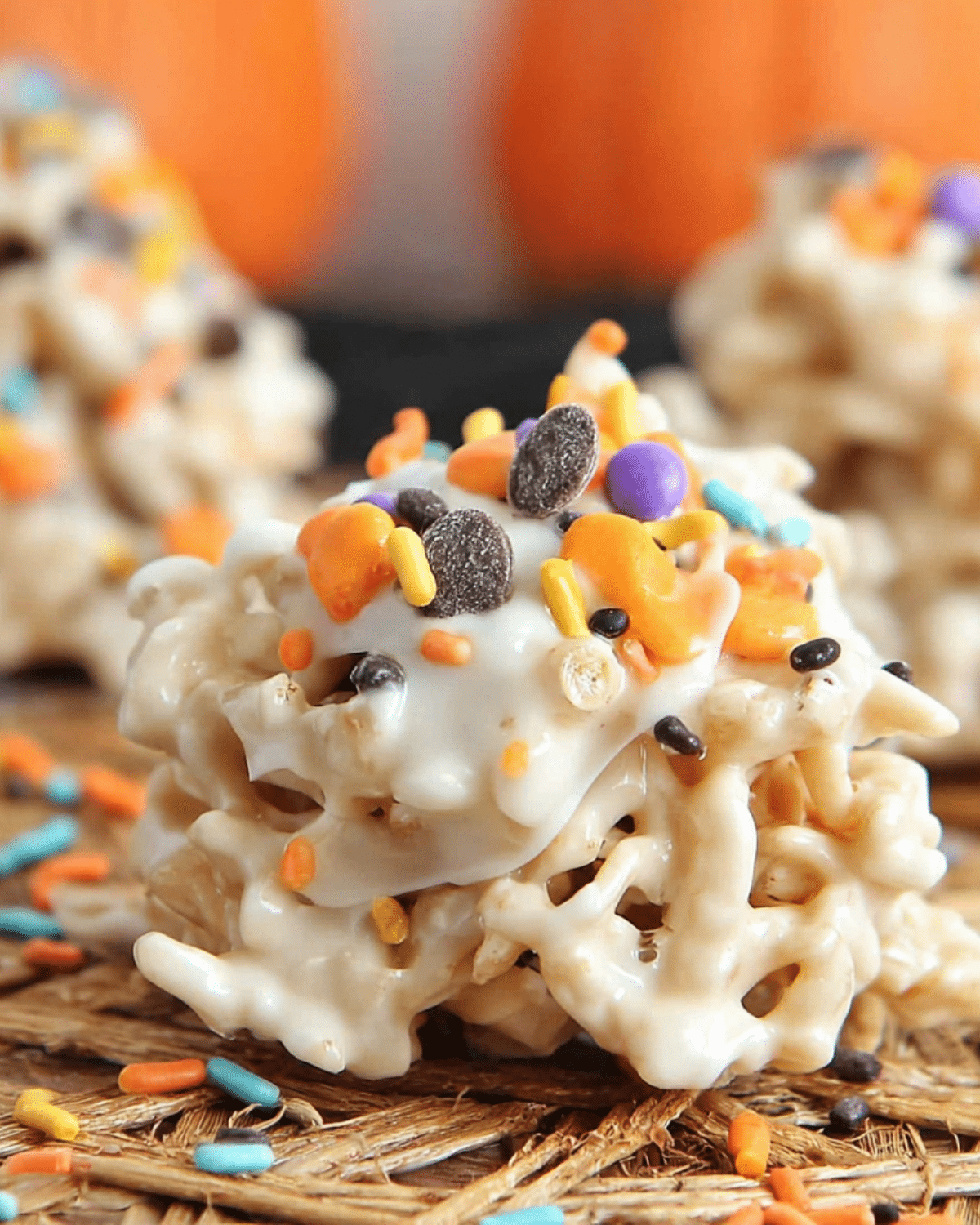 Close-up of Crockpot Halloween Haystacks covered in white chocolate and topped with colorful Halloween sprinkles.