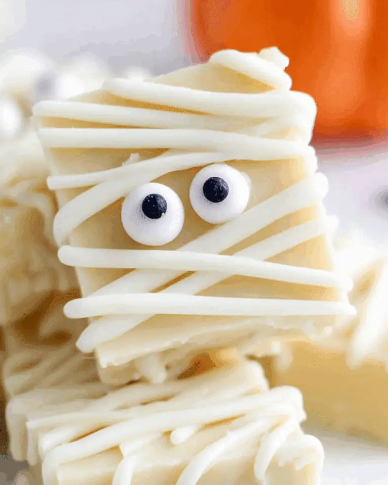 Close-up of Mummy Fudge decorated with candy eyes and white chocolate drizzle to resemble mummy wrappings.