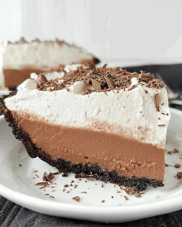 Slice of NO-BAKE CHOCOLATE PUDDING PIE with a chocolate cookie crust, creamy chocolate filling, whipped topping, and chocolate shavings.
