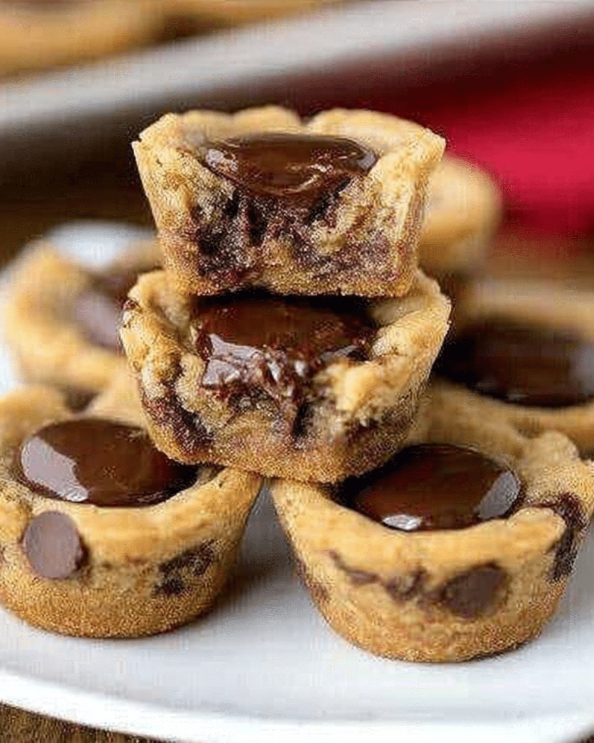 A plate stacked with Reese’s Chocolate Chip Cookie Bites filled with melted chocolate centers.