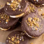 Stack of 4 ingredient Ritz S’mores Cookies coated in chocolate and sprinkled with crushed graham crackers.