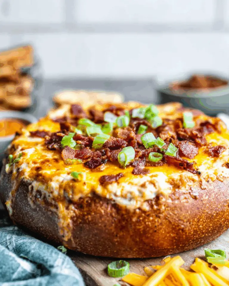 Baked Bacon Cheese Dip served in a bread bowl, topped with crispy bacon and green onions.
