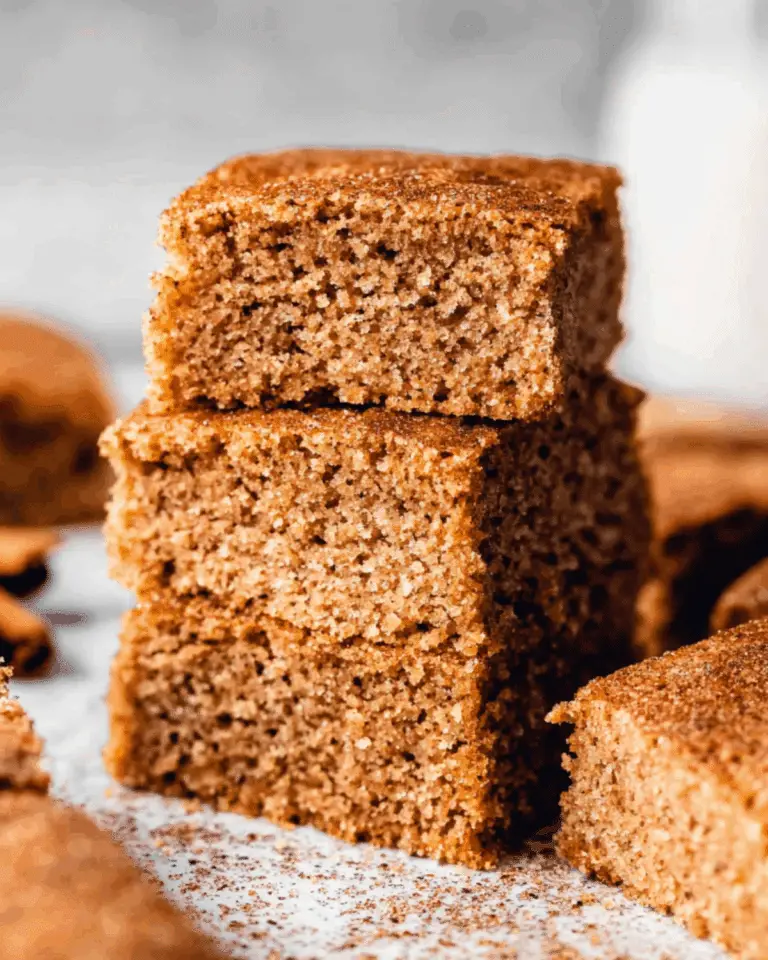 Stack of thick, moist brown butter maple blondies dusted with cinnamon sugar.