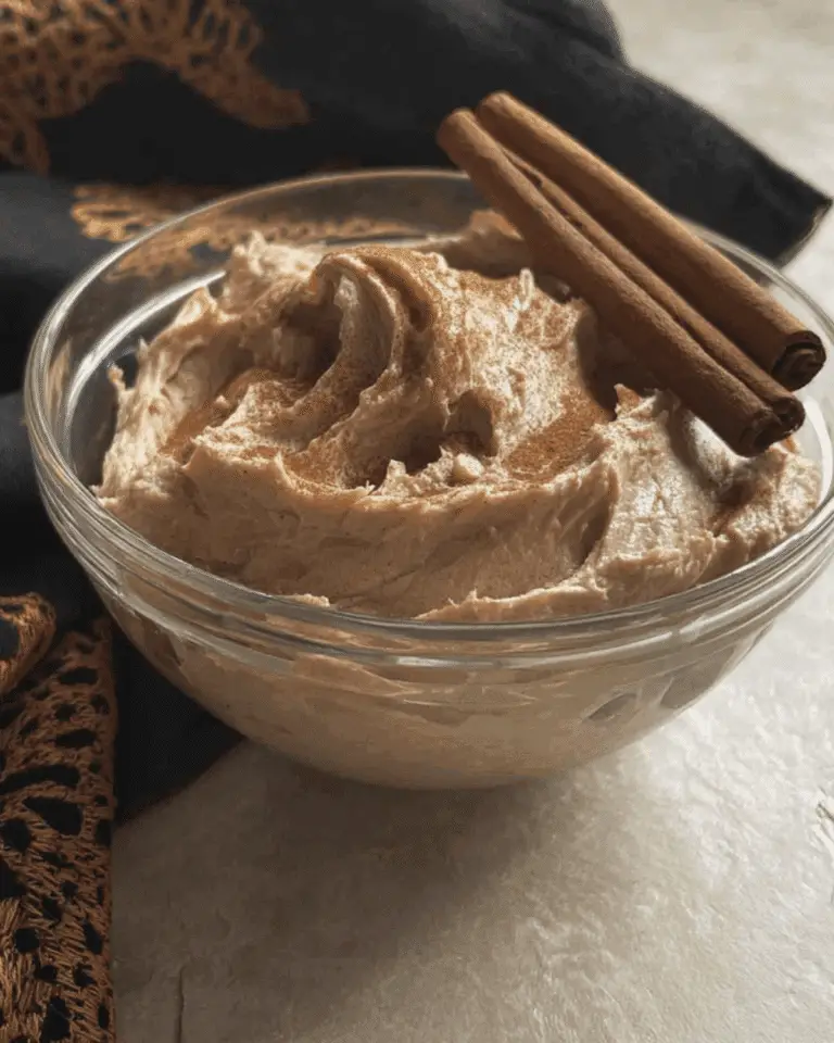 Glass bowl filled with creamy Brown Sugar Cinnamon Butter, topped with cinnamon sticks.