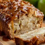 Moist slice of caramel apple fritter bread topped with gooey caramel drizzle and chunks of fresh apples.