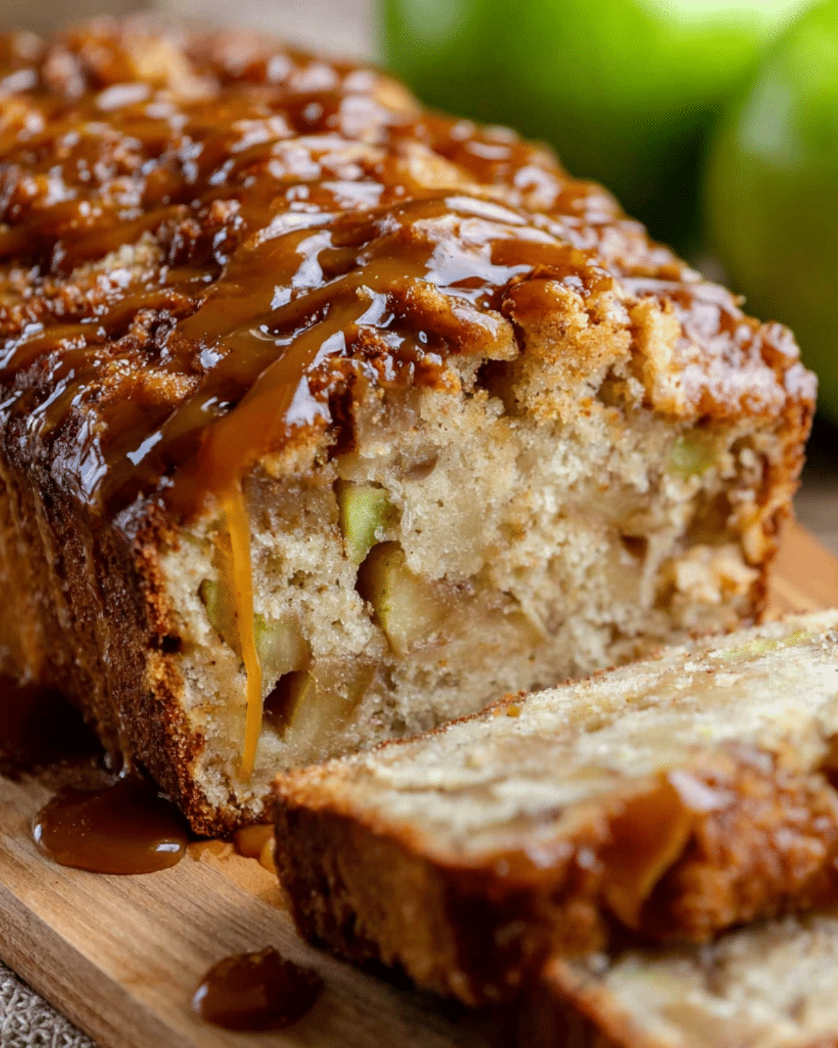 Moist slice of caramel apple fritter bread topped with gooey caramel drizzle and chunks of fresh apples.