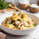 Creamy Chicken Cobbler served in a white bowl, featuring shredded chicken, peas, carrots, and golden biscuit topping.