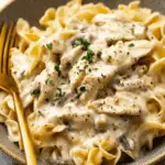 Creamy Chicken and Noodles served in a bowl with tender egg noodles and chunks of chicken, garnished with parsley.