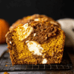 Close-up of a slice of cream cheese swirled pumpkin butter bread on a cooling rack.