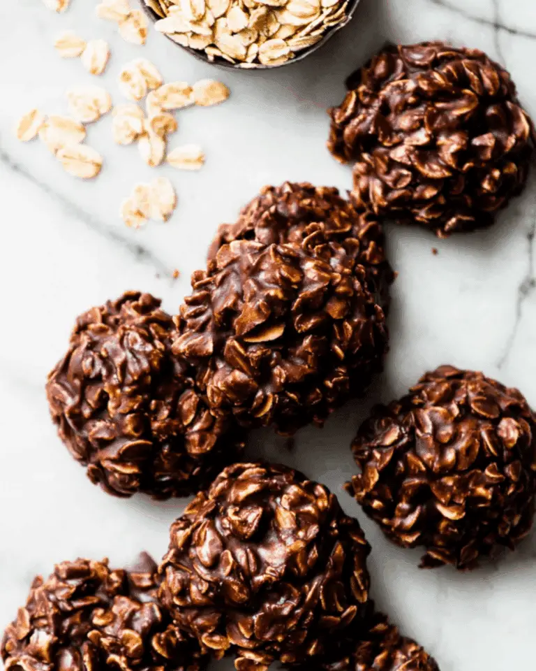 No-bake chocolate peanut butter cookies made with oats, arranged on a marble surface with raw oats scattered nearby.