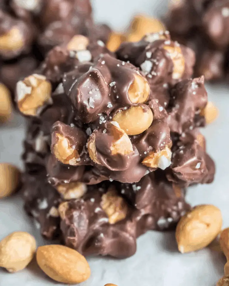 Close-up of toffee peanut clusters made with roasted peanuts coated in rich chocolate and sprinkled with sea salt.