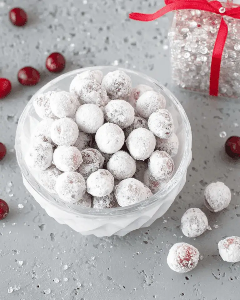 Bowl of candied cranberries coated in sugar on a festive grey background